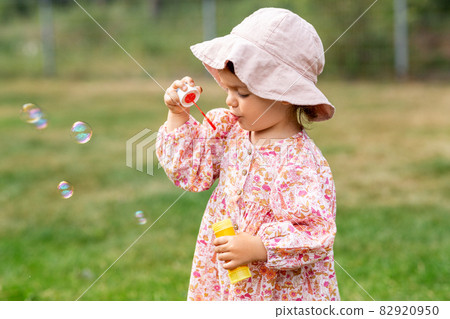 happy baby girl blowing soap bubbles in summer happy baby girl blowing soap bubbles in summer 82920950