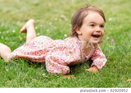 happy little baby girl lying on grass in summer happy little baby girl lying on grass in summer 82920952
