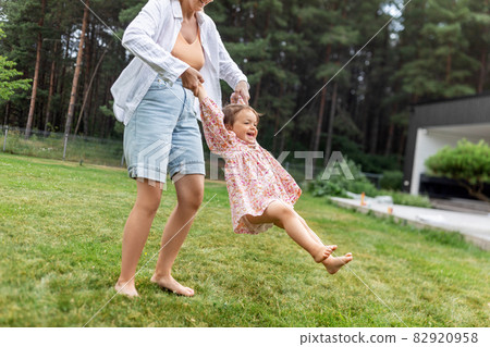 happy mother playing with baby daughter outdoors 82920958