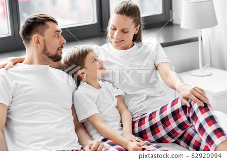 happy family in pajamas in bed in morning happy family in pajamas in bed in morning 82920994