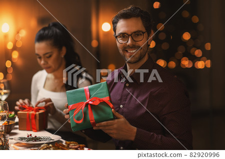 happy smiling man with christmas gift at home happy smiling man with christmas gift at home 82920996