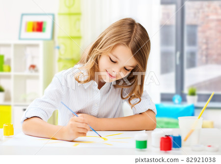 happy girl with brush and colors drawing at home happy girl with brush and colors drawing at home 82921038