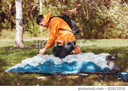 man setting up tent outdoors man setting up tent outdoors 82921058