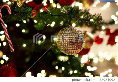 golden christmas ball decoration on fir tree 82921092