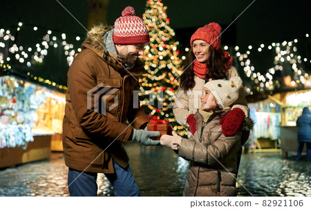 happy family with gift at christmas market in city 82921106