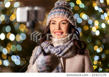 happy woman taking christmas selfie on smartphone 82921176