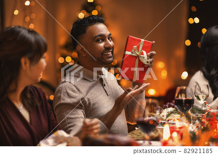 happy friends giving christmas presents at home happy friends giving christmas presents at home 82921185