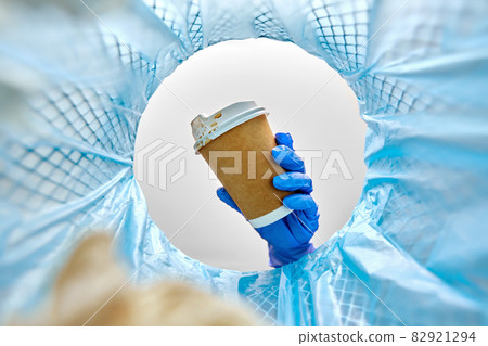 female doctor throwing coffee cup into trash can female doctor throwing coffee cup into trash can 82921294