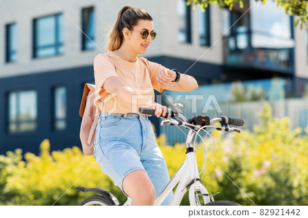 woman with smart watch riding bicycle in city woman with smart watch riding bicycle in city 82921442