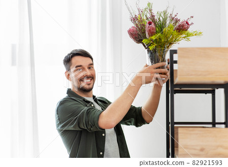 man decorating home with flower or houseplant 82921593