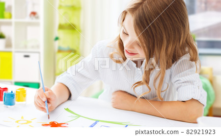 happy girl with brush and colors drawing at home happy girl with brush and colors drawing at home 82921923