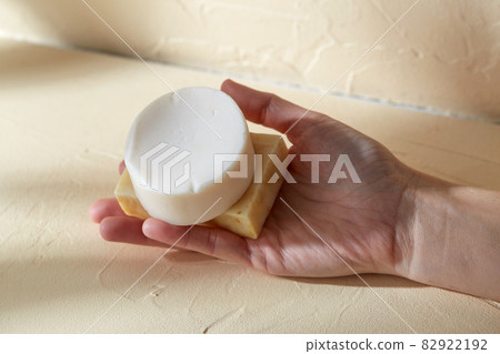 hand holding bar of craft soap on beige background hand holding bar of craft soap on beige background 82922192