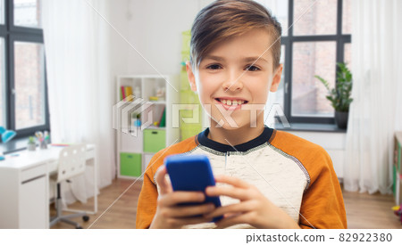 boy with smartphone texting or playing at home 82922380