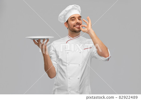happy smiling male chef holding empty plate happy smiling male chef holding empty plate 82922489