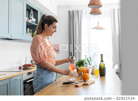 woman making cocktail drinks at home kitchen woman making cocktail drinks at home kitchen 82922534