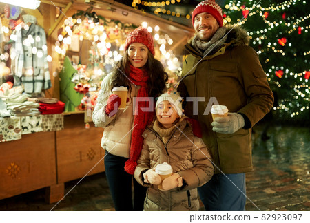 family with takeaway drinks at christmas market 82923097
