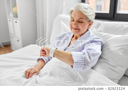 happy senior woman sitting in bed at home bedroom happy senior woman sitting in bed at home bedroom 82923124
