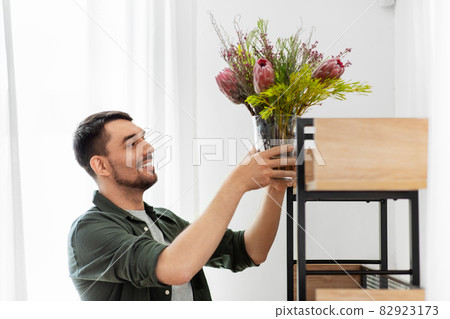 man decorating home with flower or houseplant 82923173