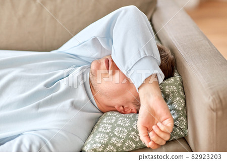 bored or lazy young man lying on sofa at home bored or lazy young man lying on sofa at home 82923203
