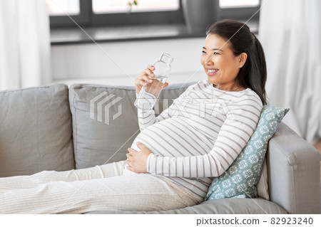 pregnant woman with water in glass bottle at home 82923240