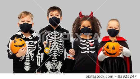 children in halloween costumes and reusable masks 82923247