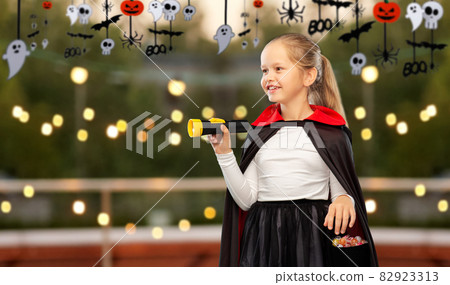 girl in halloween costume of dracula with candies girl in halloween costume of dracula with candies 82923313