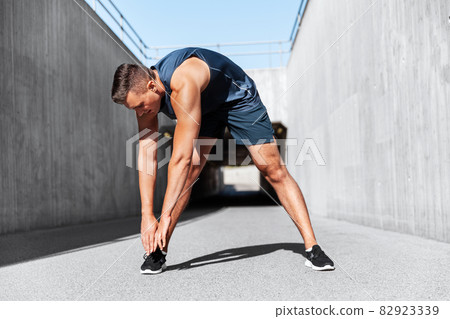 man doing sports and stretching outdoors 82923339