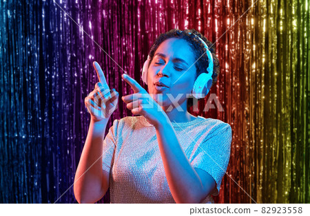 woman in headphones listening to music and dancing woman in headphones listening to music and dancing 82923558