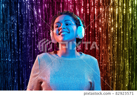 woman in headphones listening to music at party 82923571