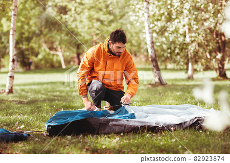 man setting up tent outdoors 82923874