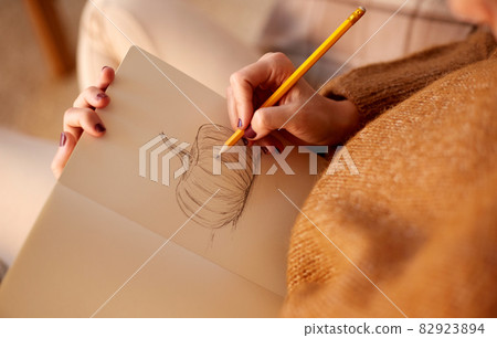 woman drawing pumpkin in sketchbook on halloween woman drawing pumpkin in sketchbook on halloween 82923894
