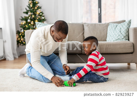 happy father playing with son on christmas at home happy father playing with son on christmas at home 82923927