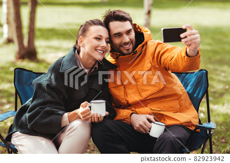 couple drinking tea and taking selfie at tent camp couple drinking tea and taking selfie at tent camp 82923942