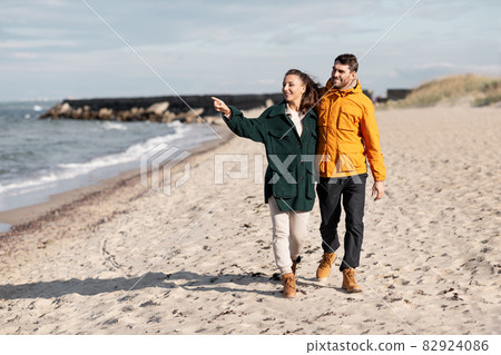 couple walking along autumn beach couple walking along autumn beach 82924086