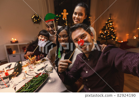 friends taking selfie on christmas dinner at home 82924190