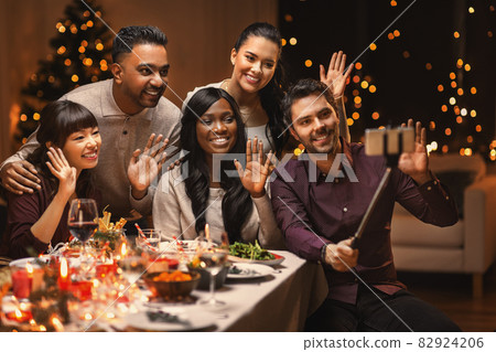 friends taking selfie on christmas dinner at home 82924206