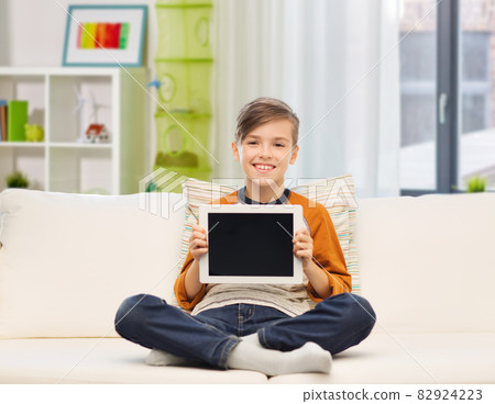 smiling boy with tablet computer at home smiling boy with tablet computer at home 82924223