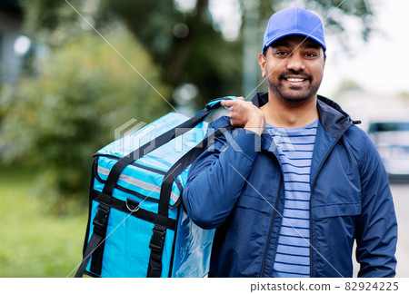 happy smiling indian delivery man with bag in city happy smiling indian delivery man with bag in city 82924225
