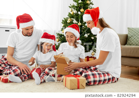 happy family opening christmas gifts at home happy family opening christmas gifts at home 82924294