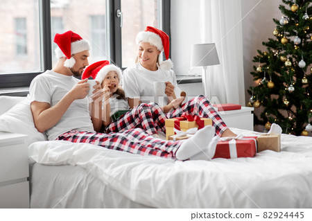 happy family eating coookies in bed on christmas happy family eating coookies in bed on christmas 82924445