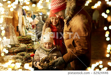 happy family buing wreath at christmas market happy family buing wreath at christmas market 82924446