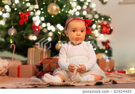 baby girl at christmas tree with gifts at home baby girl at christmas tree with gifts at home 82924485