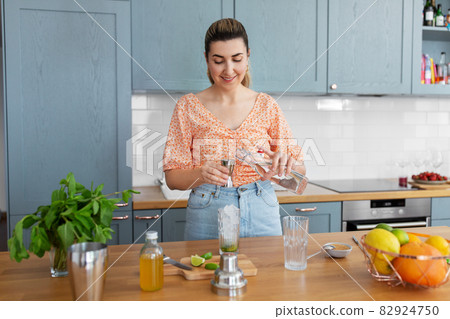 woman making cocktail drinks at home kitchen woman making cocktail drinks at home kitchen 82924750
