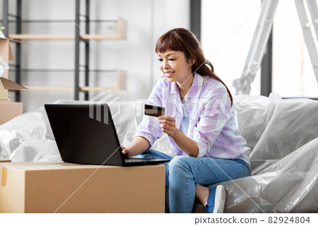 woman with laptop and credit card at new home woman with laptop and credit card at new home 82924804