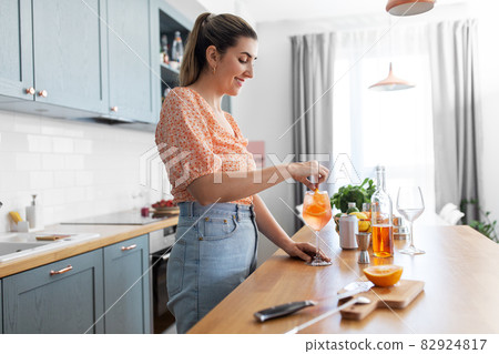 woman making cocktail drinks at home kitchen woman making cocktail drinks at home kitchen 82924817