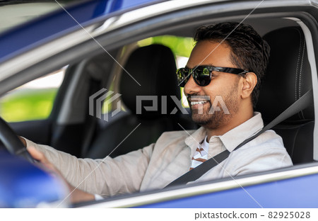 smiling indian man in sunglasses driving car smiling indian man in sunglasses driving car 82925028