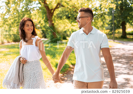 happy couple with picnic blanket at summer park happy couple with picnic blanket at summer park 82925039