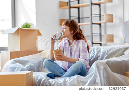 happy woman moving to new home and eating wok 82925087