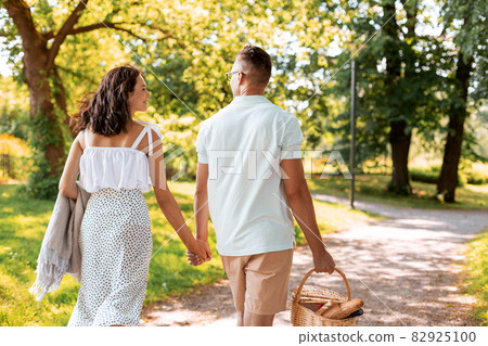 happy couple with picnic basket at summer park happy couple with picnic basket at summer park 82925100