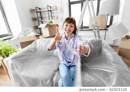smiling asian woman taking selfie at new home smiling asian woman taking selfie at new home 82925130